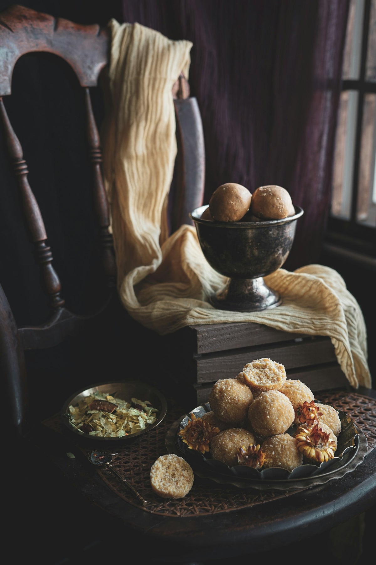 Round ladoos in a dark metal bowl