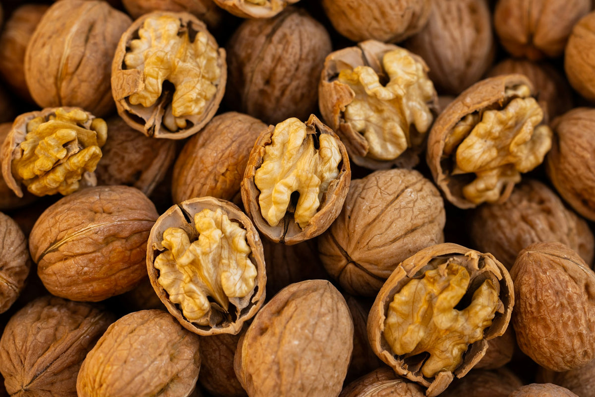 Whole and cracked walnuts showing their kernels