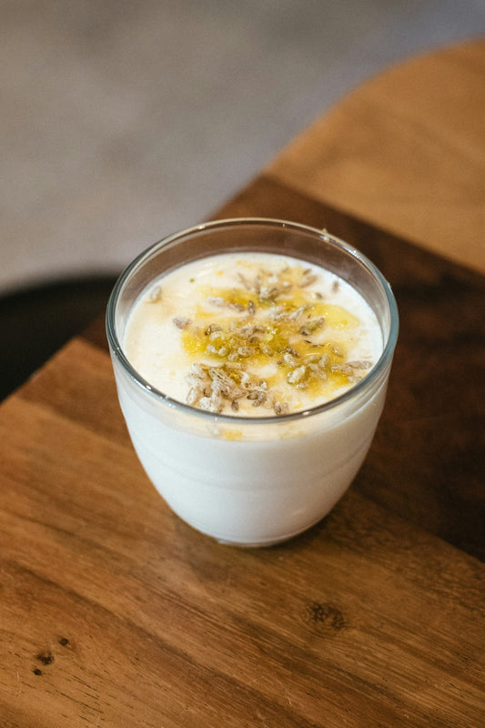 A glass of chilled milk topped with chopped nuts and saffron